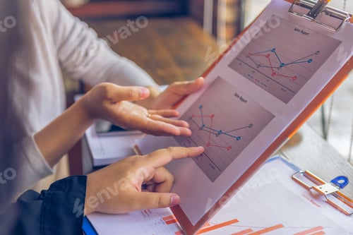 Preview: Close Up Of Women Hands Pointing On Sales Graph Document