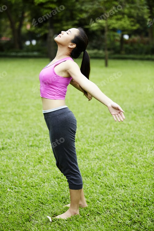 Preview: Attractive Healthy Asian Woman Doing Yoga In The Park