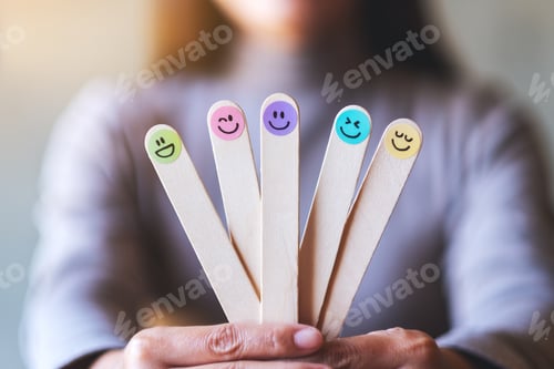 Preview: A Woman Holding Colorful Hand Draw Happy Emotion Faces On Wooden Stick