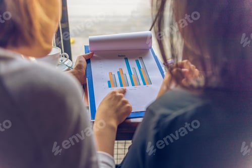 Preview: Rear View Of Woman Pointing On Sales Chart Document