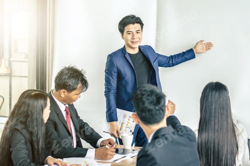Preview: Photo Of Successful Young Manager Standing Making A Presentation Financial Diagram While The Others