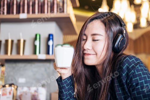 Preview: A Beautiful Asian Woman Close Her Eyes And Listening To Music With Headphone While Drinking Coffee
