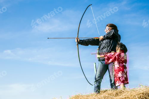 Preview: Asian Mother And Daugther Playing Arrow On Straw And Clear Sky