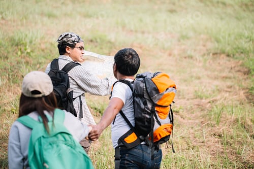 Preview: Group Of Backpacking Hikers Going To Mountain Top And Navigating By Map. Backpackers Or Hikers