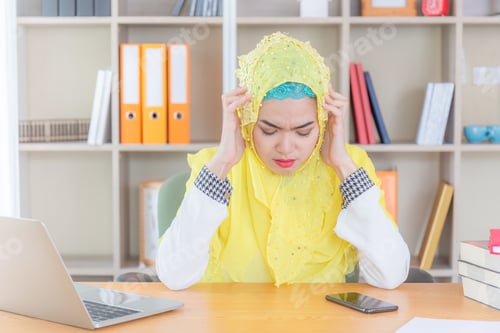 Preview: Serious Young Business Arab Middle Eastern Muslim Woman Sitting At The Workplace