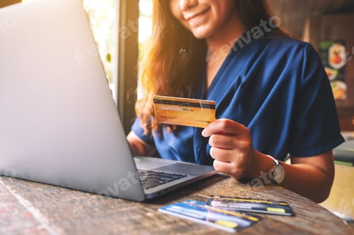 Preview: Closeup Image Of A Business Woman Holding Credit Card While Using Laptop Computer