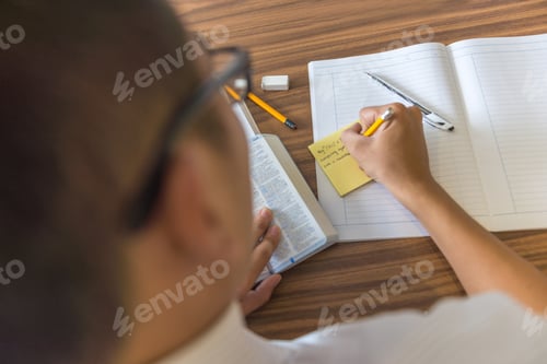 Preview: Rear View Of Young Student Writing Note