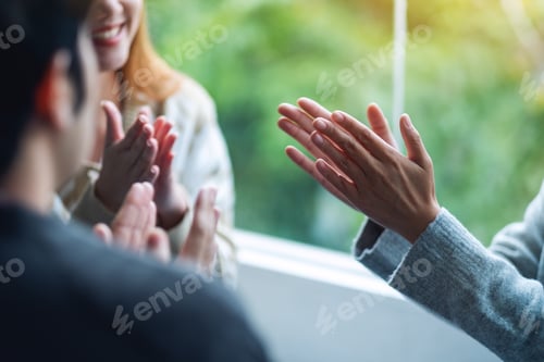 Preview: A Group Of Young People Clapping Hands While Sitting Together