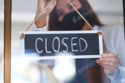 Preview: A Waitress Wearing Protective Face Mask Hanging Closed Sign On Front Door Due To Coronavirus