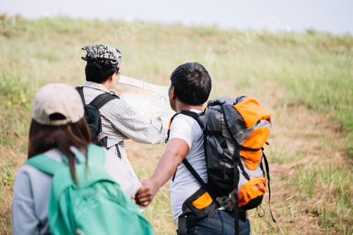 Preview: Group Of Backpacking Hikers Going To Mountain Top And Navigating By Map. Backpackers Or Hikers