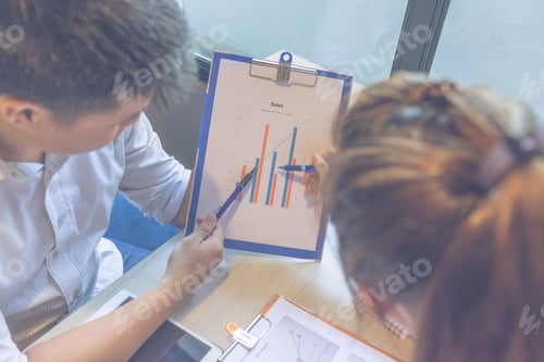 Preview: Close Up Of Businessman And Businesswoman Discuss About Sales Report
