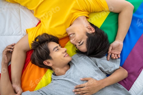 Preview: Happy Asian Homosexual Gay Couple Lying On Rainbow Pride Flag. Lgbt Concept.
