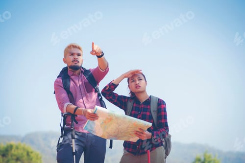 Preview: Young Couple Hiking On The Mountain With Backpack On Peak Of Mountain, Looking A Map.