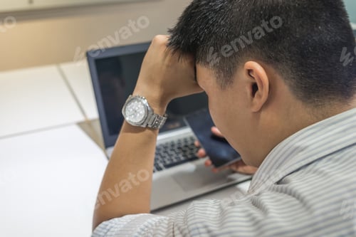 Preview: Tired Asian Businessman With Laptop Computer In The Office
