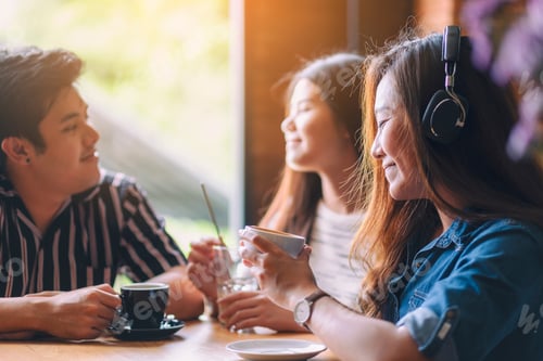 Preview: A Beautiful Asian Woman Enjoy Listening To Music With Headphone While Drinking Coffee With Friends