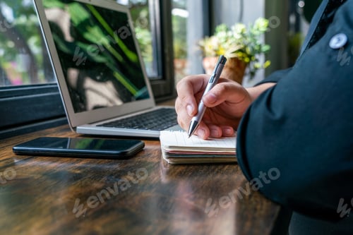 Preview: Human Hand Holding Pen And Writing Notebook