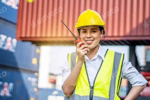 Preview: Young Confident Woman Engineer Smiling And Using Radio Communication And Wearing Yellow Safety