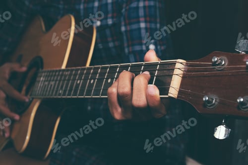 Preview: Hands Playing an Acoustic Guitar in Dark Light