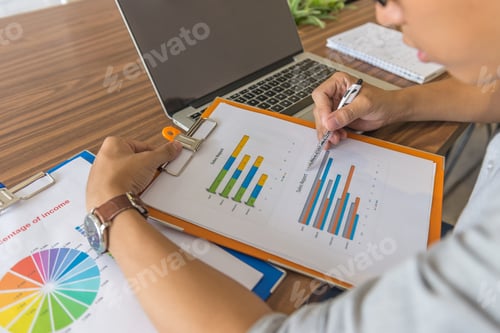 Preview: Young Businessman Reading Financial Graph In Document