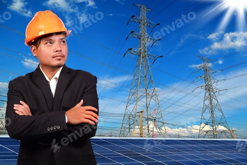 Preview: Engineer Man With Solar Panel Against High Voltage Towers Background.
