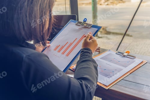 Preview: Close Up Of Woman In Black Shirt Reading Chart Paperwork