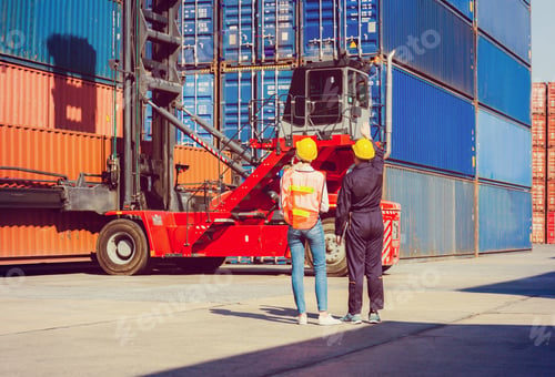 Preview: Worker Man In Hardhat And Safety Vest Holding Laptop And Female Engineer Control Loading Containers