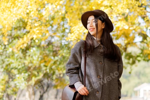 Preview: Portrait Of Young Chinese Woman In Fashionable Coat And Hat With Golden Autumn Forest Background In