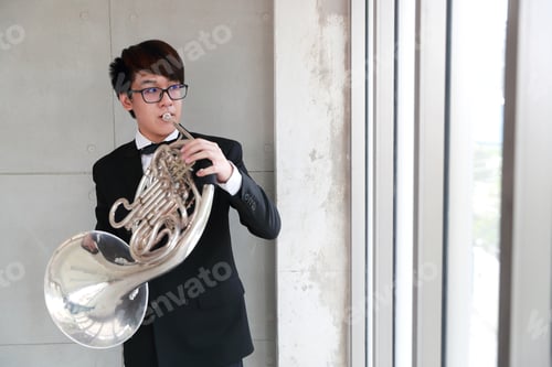Preview: Young Musician Man Wearing Black Suit Playing French Horns