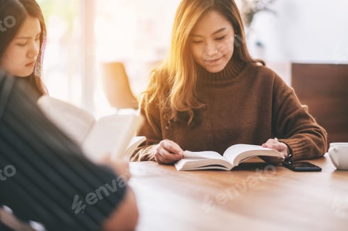 Preview: Group Of People Sitting And Enjoyed Reading Book Together On Wooden Table