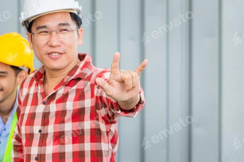 Preview: Cheerful Engineer Man In Hard Hat Showing Hand In I Love You Sign