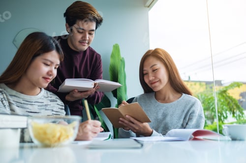 Preview: Group Of Young Students Tutoring And Catching Up Workbook With Friends