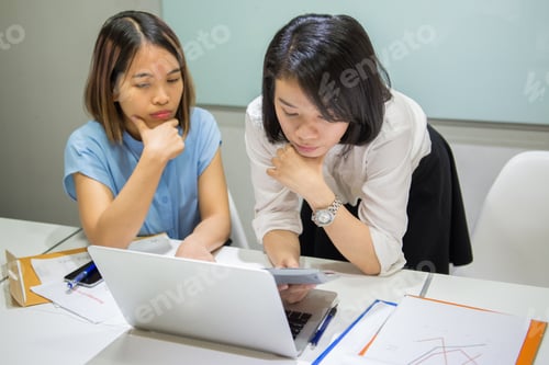 Preview: Two Team Member Talking About Sales Chart Report On Laptop