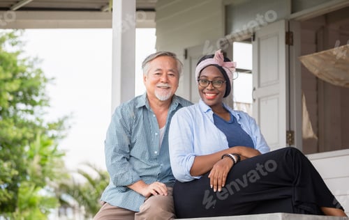 Preview: Senior Asian Man And Cheerful African American Woman Sitting Relax And Looking At Camera