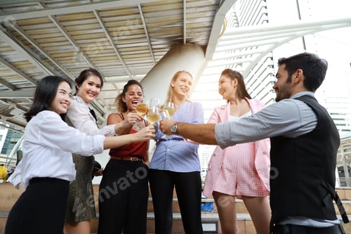 Preview: Successful Multiethnic Business People Are Clinking Glasses Of Champagne With Smiling While