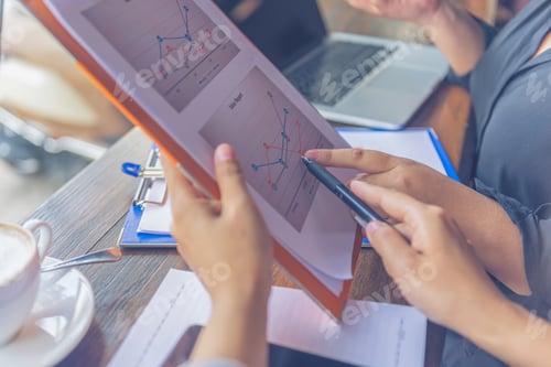 Preview: Close Up Of Two Women Hands Pointing Business Chart Paperwork