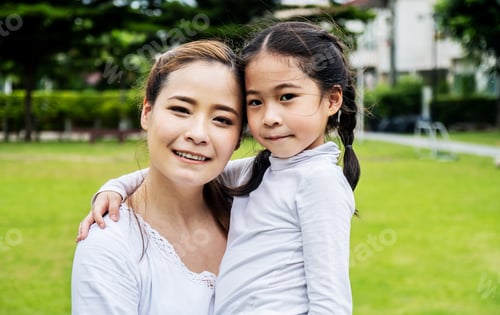 Preview: Cute Asian Mother And Daughter Smiling And Hugging In Love Playing In The Park