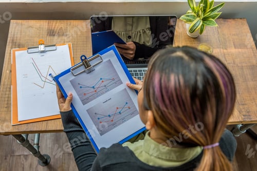 Preview: Top View Of Woman Holding And Analyzing Business Sales Document