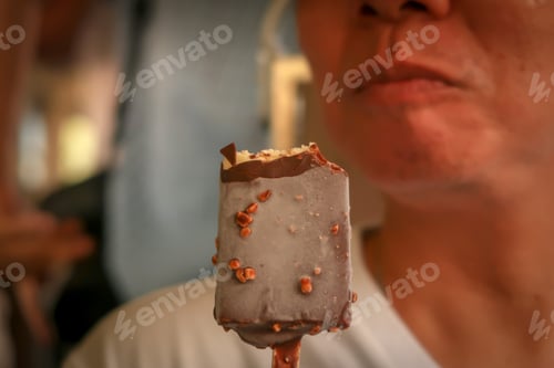 Preview: Asian Man Eating Delicious Chocolate Vanilla Ice Pop