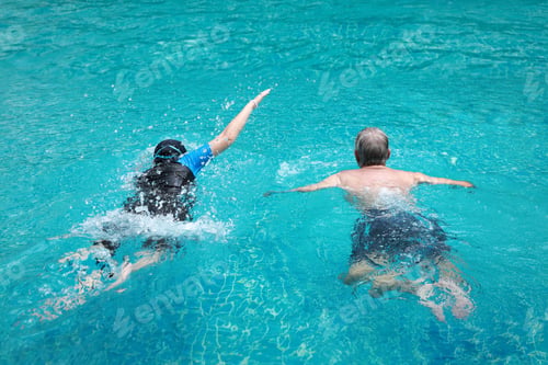 Preview: Rear View Couple Of Pensioners Seniors In Swimming Pool Having Fun And Swimming Together Outdoor In