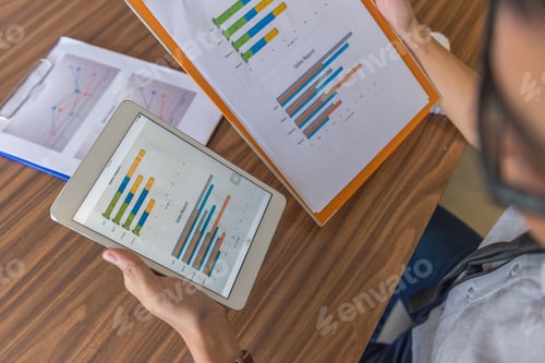 Preview: Office Man Compare Financial Data On Tablet And Document Report