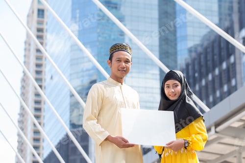 Preview: Young Arab Man And Young Arab Woman Holding A White Blank Horizontal Board At Front Modern Building