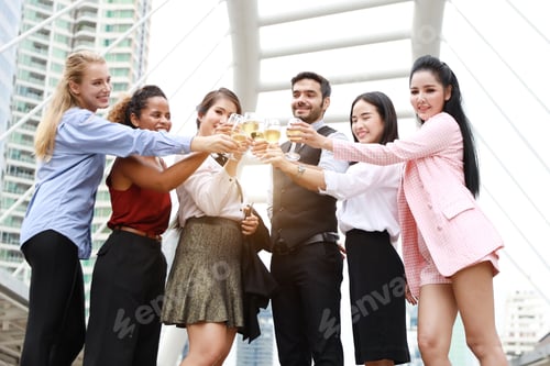 Preview: Successful Multiethnic Business People Are Clinking Glasses Of Champagne With Smiling While