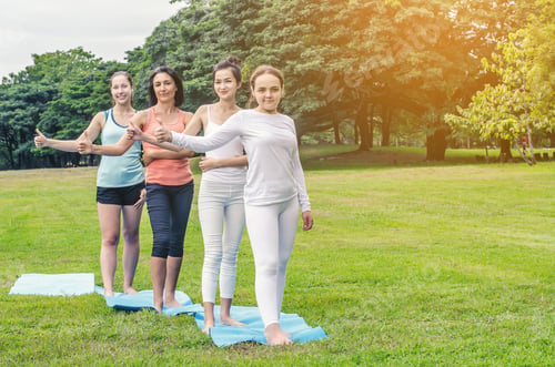 Preview: Group Of Four Smiling Women Stand Up On Mat In The Park