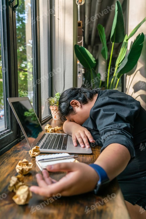 Preview: Millennial Falling Asleep Next To Laptop And Crumpled Paper Balls