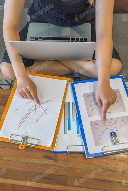 Preview: High Angle View Of Young Freelancer Comparing Financial Reports
