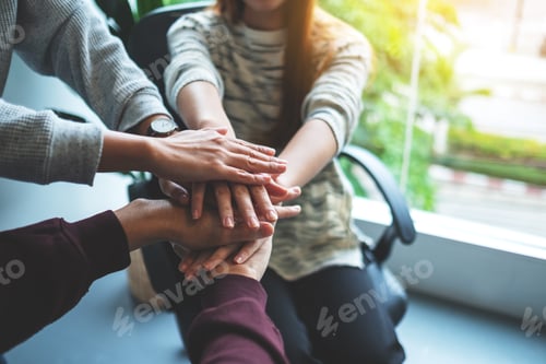 Preview: Closeup Image Of Business Team Standing And Joining Their Hands Together In Office