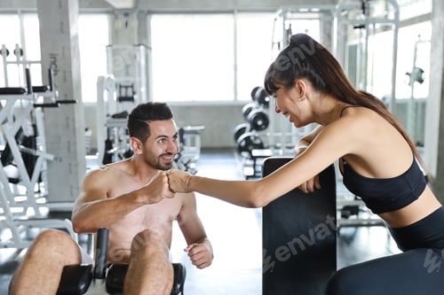 Preview: Fitness Caucasian Man And Woman Exercising In Gym And Doing Fist Bump With Smiling Face