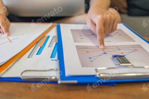 Preview: Young Businesswoman Comparing Financial Documents At The Office