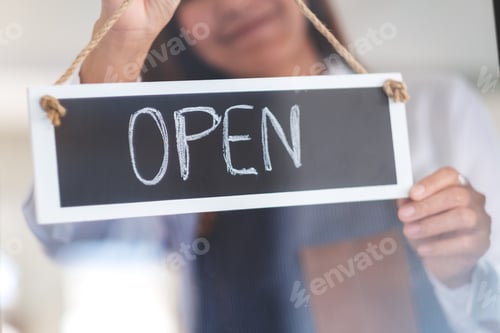Preview: A Young Asian Entrepreneur Or A Waitress Hanging Open Sign On The Shop Front Door
