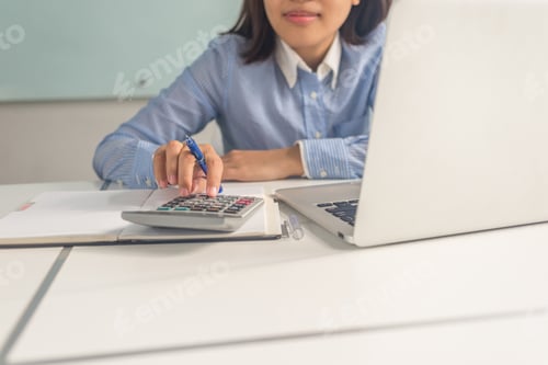 Preview: Young Asian Woman Using Calculator To Count Number Of Sales In Modern Office Meeting Room